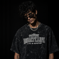 Person wearing a black t-shirt with 'Bhakti.Life' text on a dark background