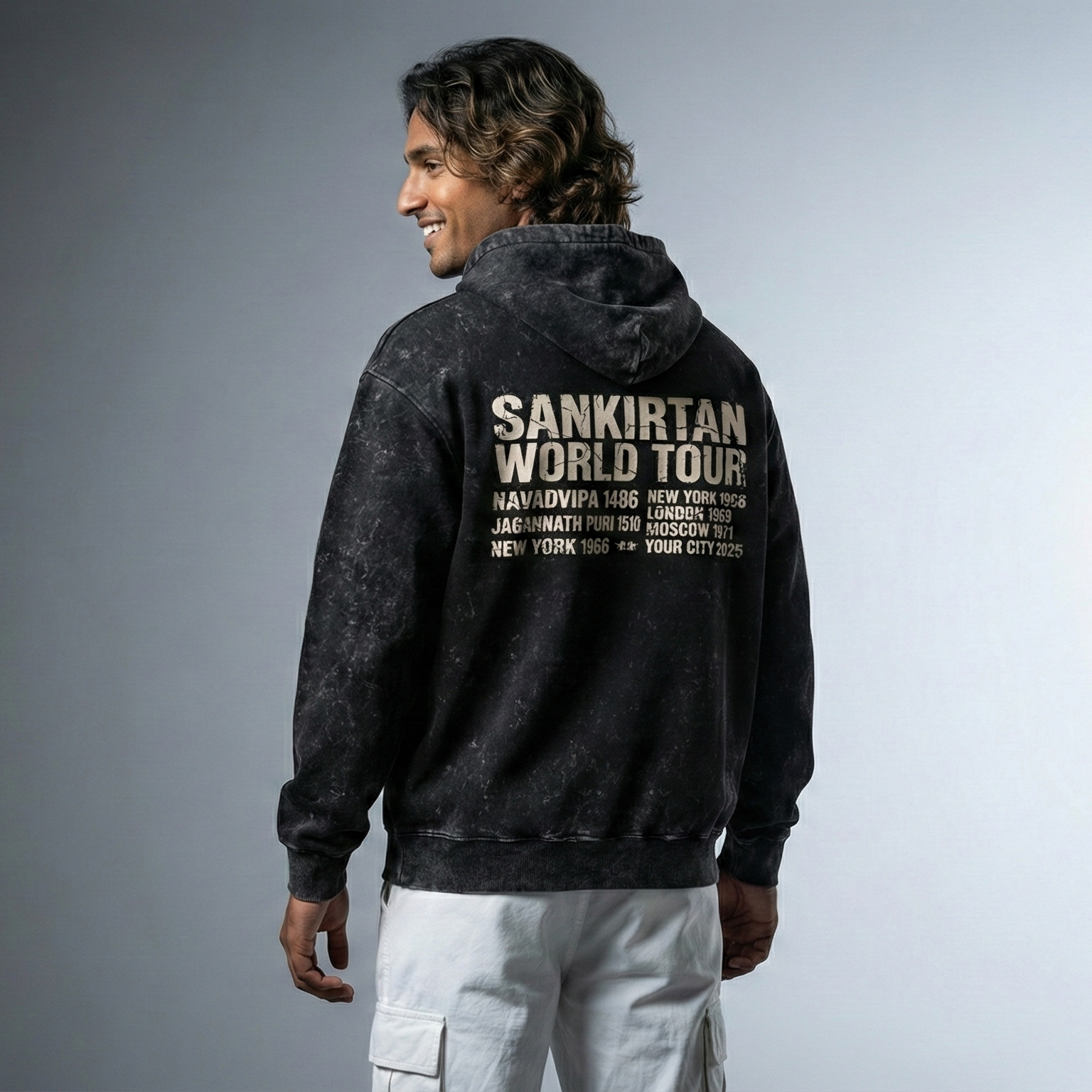 Person wearing a black hoodie with 'Sankriyan World Tour' text on the back against a gray background