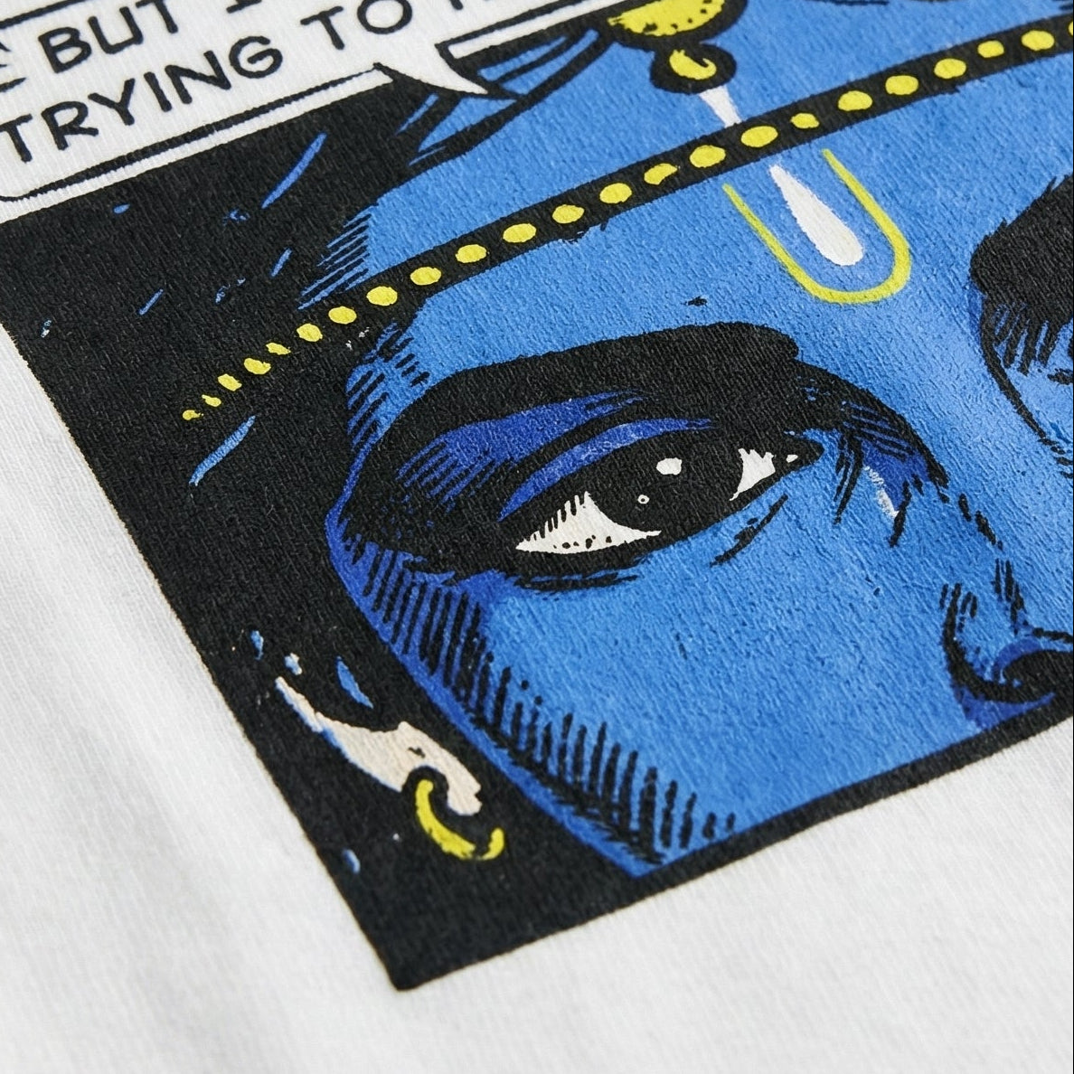 White t-shirt with a blue face design and text on a white background